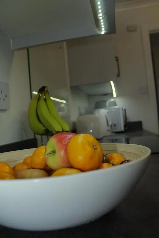 a bowl of fruit on a counter with bananas and oranges at Covesea Horizon in Elgin