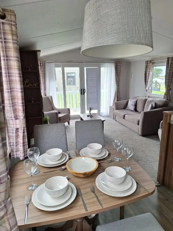 a dining room table with plates and wine glasses at Northern Lights in Lossiemouth