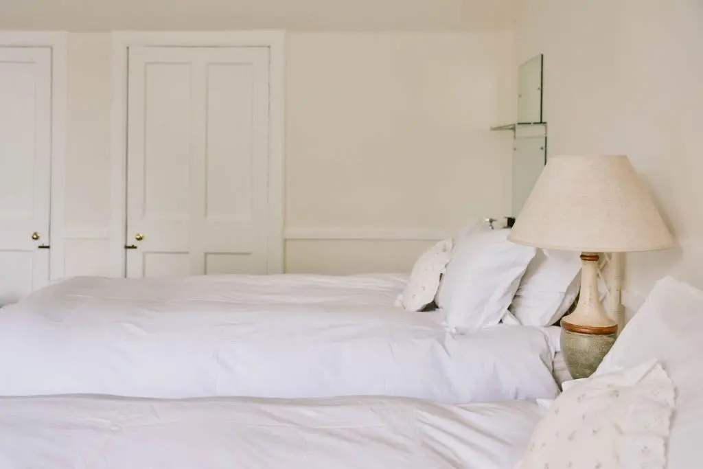 a bedroom with a white bed and a lamp at The Secret Loch in Lhanbryd