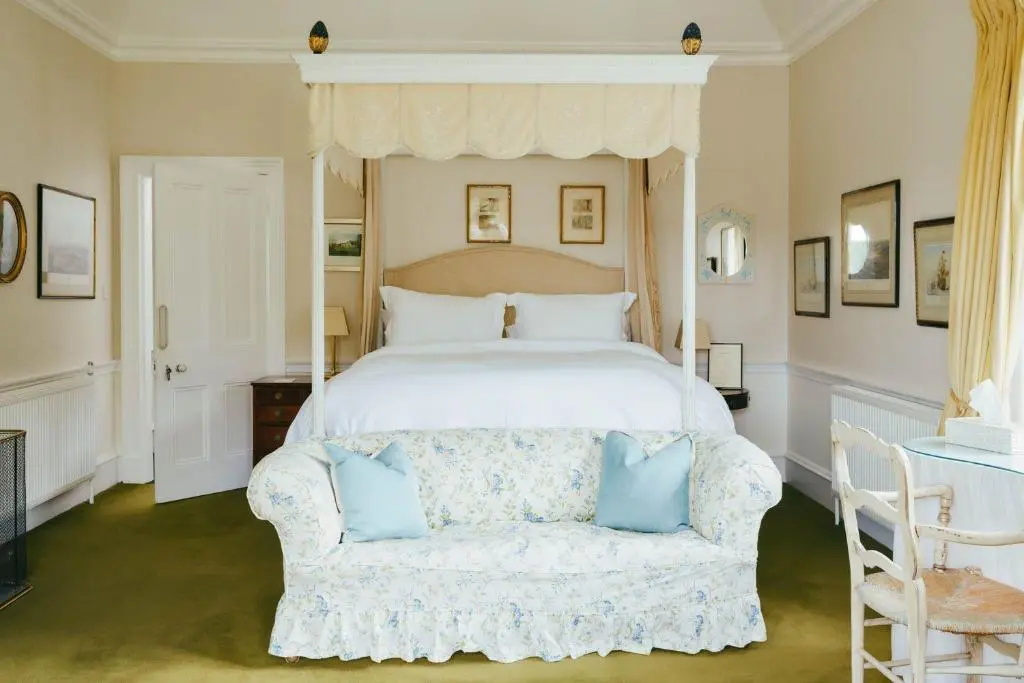 a bedroom with a white bed and a couch at The Secret Loch in Lhanbryd