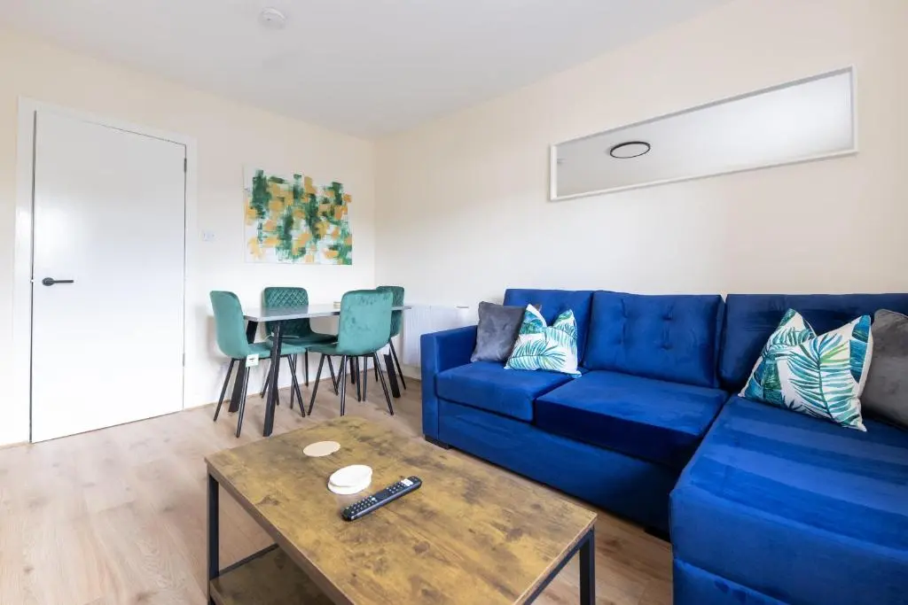a living room with a blue couch and a table at 1 BDR Flat At Caledonia Luxe Stays Short Lets & Serviced Accommodation Inverness in Inverness