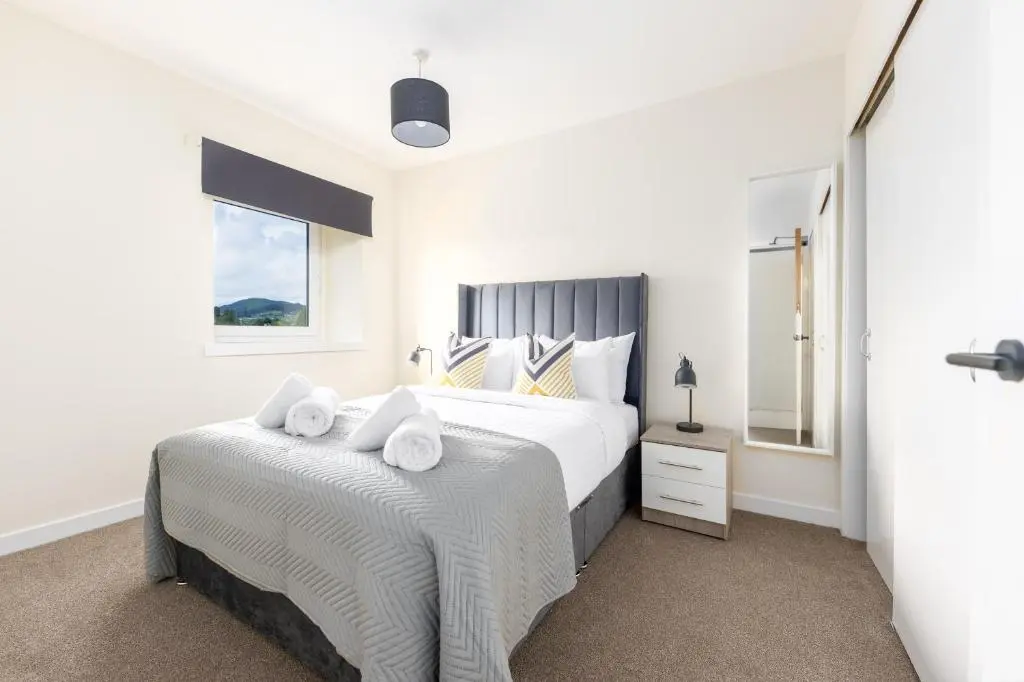 a bedroom with a bed with towels on it at 1 BDR Flat At Caledonia Luxe Stays Short Lets & Serviced Accommodation Inverness in Inverness