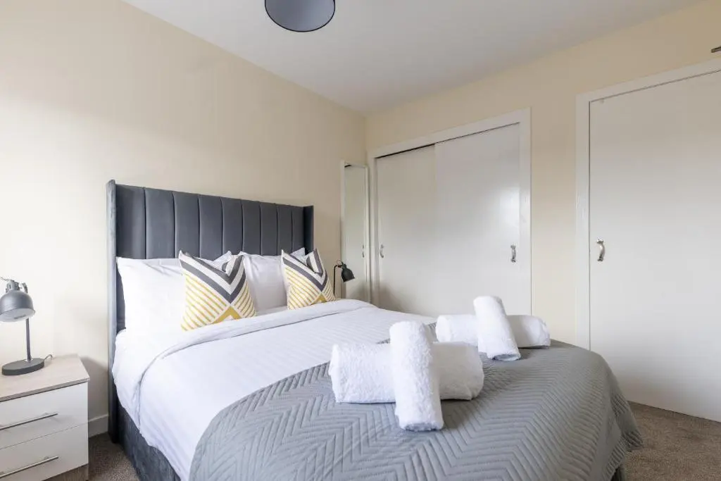 a bedroom with a large bed with towels on it at 1 BDR Flat At Caledonia Luxe Stays Short Lets & Serviced Accommodation Inverness in Inverness