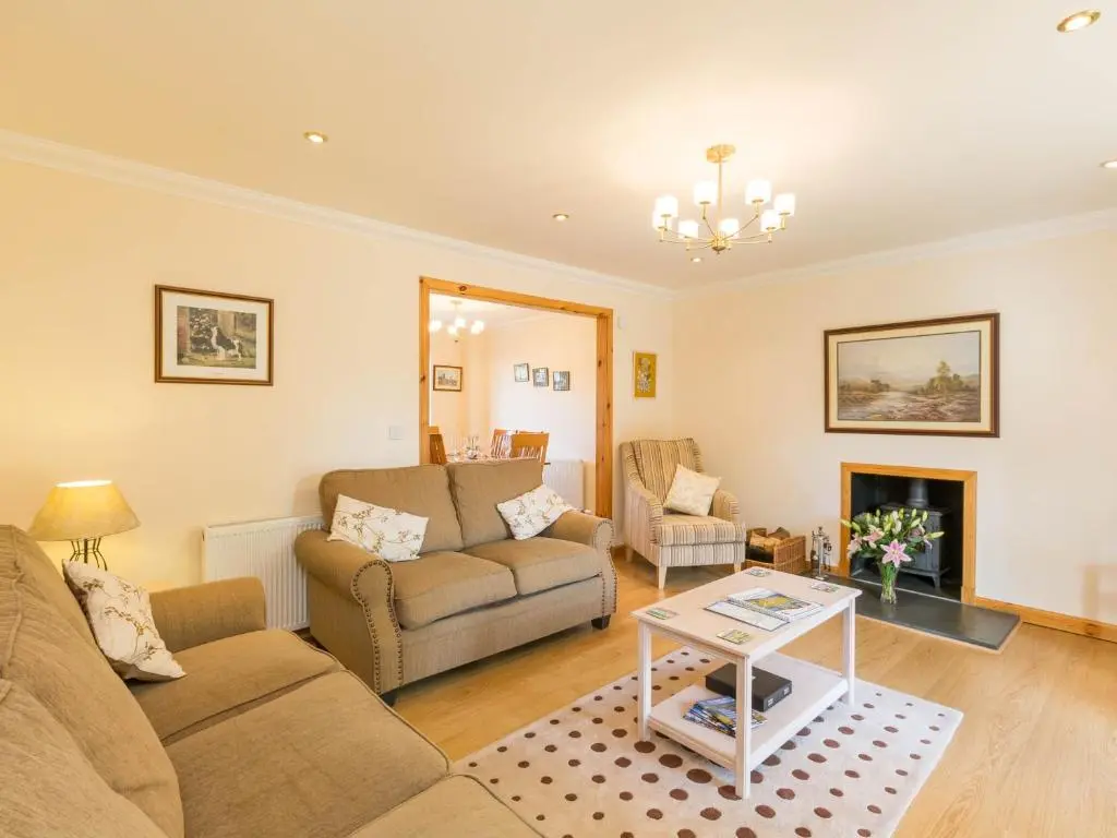 a living room with a couch and a fireplace at Broombank Cottage in Inverness