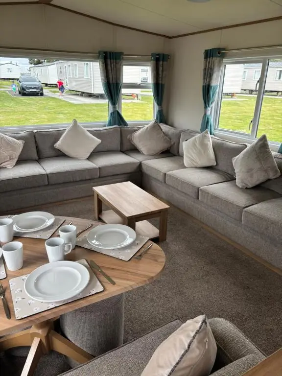 a living room with a couch and a table at Lighthouse View in Lossiemouth