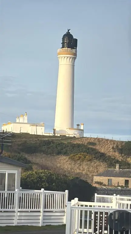 a lighthouse on top of a hill with a white fence at Lighthouse View in Lossiemouth