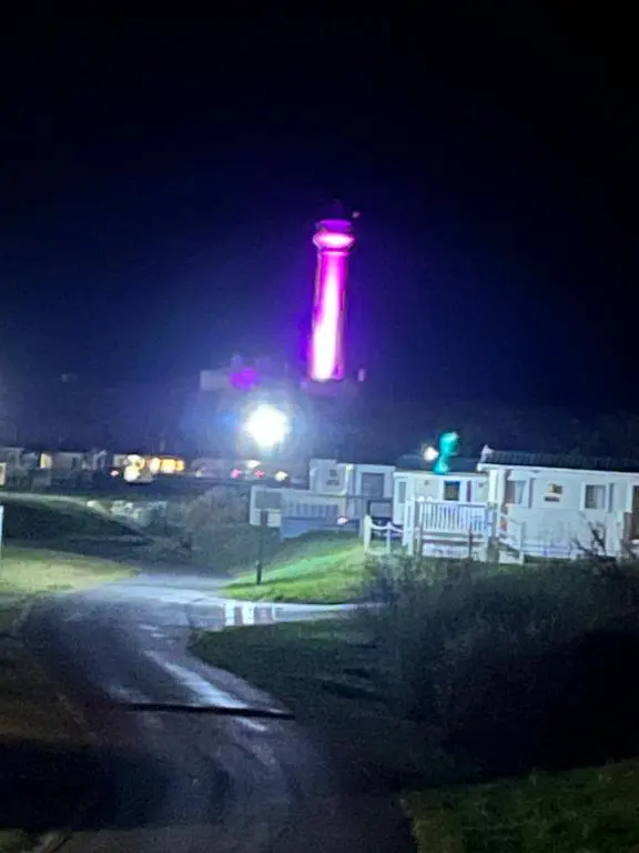 a red light tower at night with a building at Lighthouse View in Lossiemouth