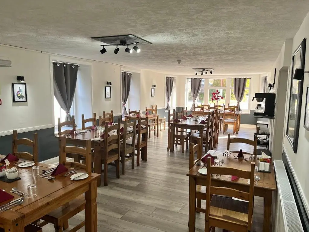 a dining room with wooden tables and chairs at Novar Arms Hotel in Evanton