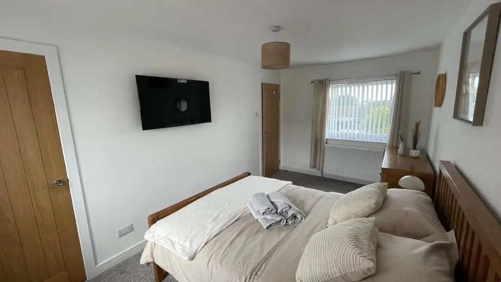 a bedroom with a bed with a television on the wall at The Den - by Caithness Luxury Apartments NC500 - 2 Bedroom holiday home - Sleeps Work teams upto 2 & holiday makers upto 4 in Wick