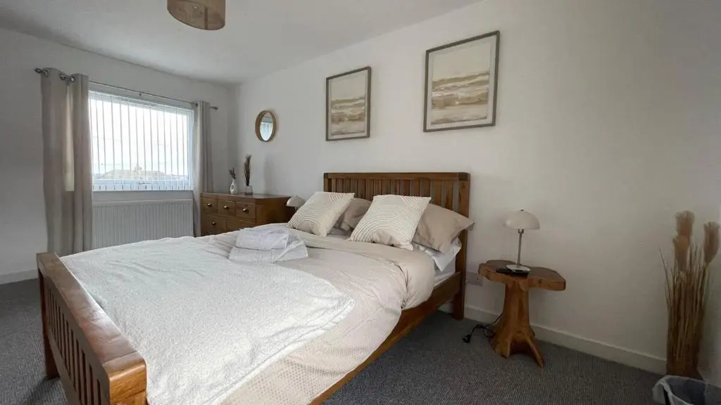 a bedroom with a large white bed and a table at The Den - by Caithness Luxury Apartments NC500 - 2 Bedroom holiday home - Sleeps Work teams upto 2 & holiday makers upto 4 in Wick
