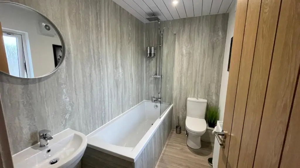 a bathroom with a tub and a toilet and a sink at The Den - by Caithness Luxury Apartments NC500 - 2 Bedroom holiday home - Sleeps Work teams upto 2 & holiday makers upto 4 in Wick