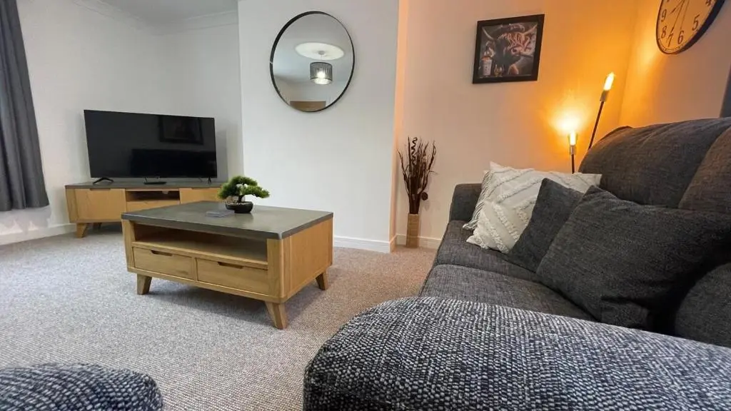 a living room with a couch and a tv at The Den - by Caithness Luxury Apartments NC500 - 2 Bedroom holiday home - Sleeps Work teams upto 2 & holiday makers upto 4 in Wick