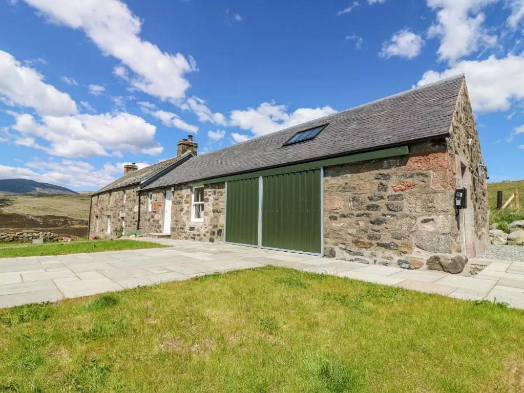 an old stone house with a green garage at The Crannach in Blairgowrie