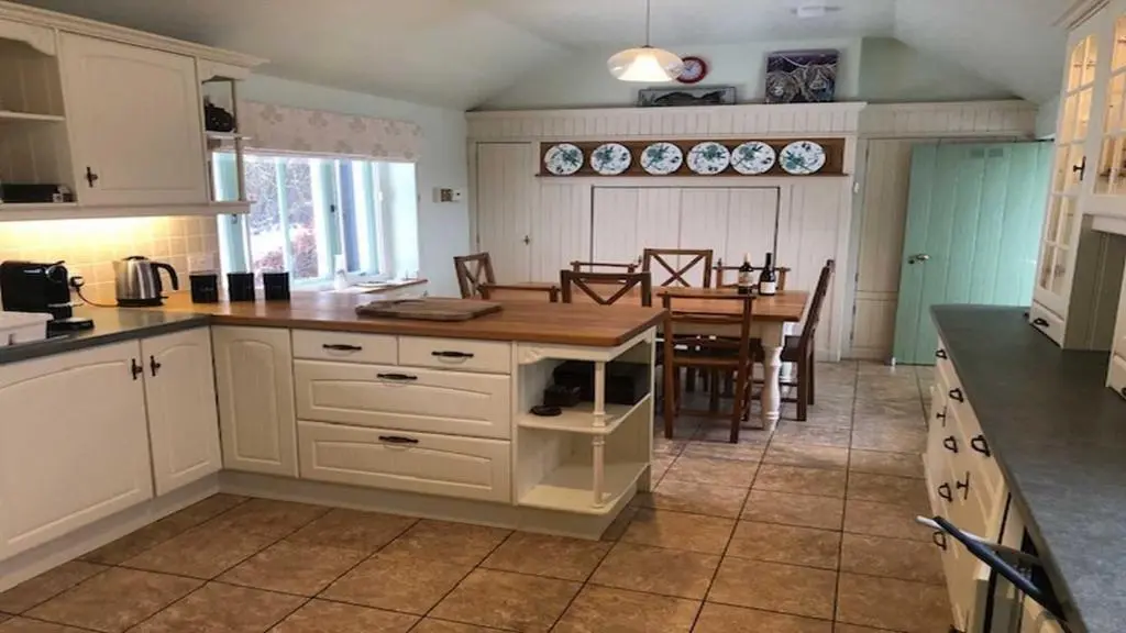 a kitchen with a table and a dining room at Dhivach Lodge in Drumnadrochit