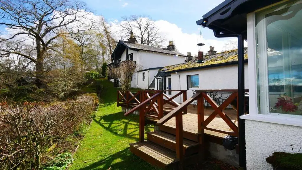 a house with a wooden deck next to a house at Dhivach Lodge in Drumnadrochit