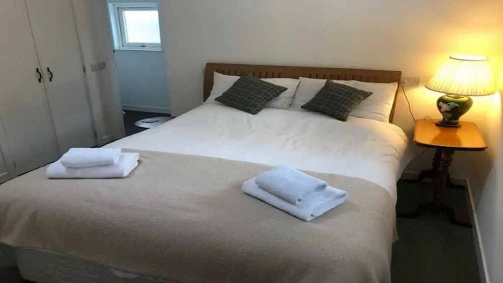 a bedroom with a bed with towels on it at Coach House in Drumnadrochit