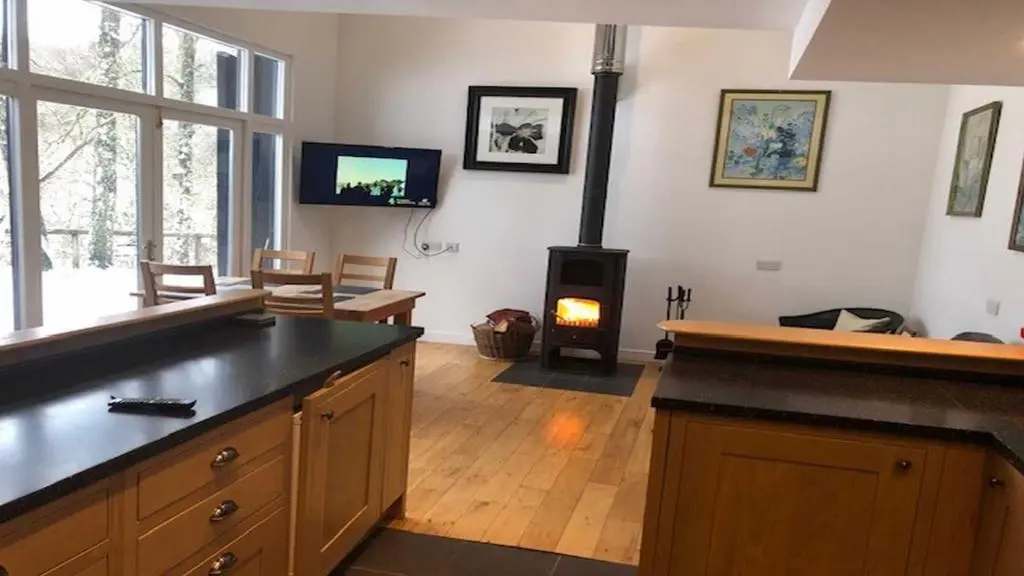 a kitchen with a stove and a living room at Coach House in Drumnadrochit
