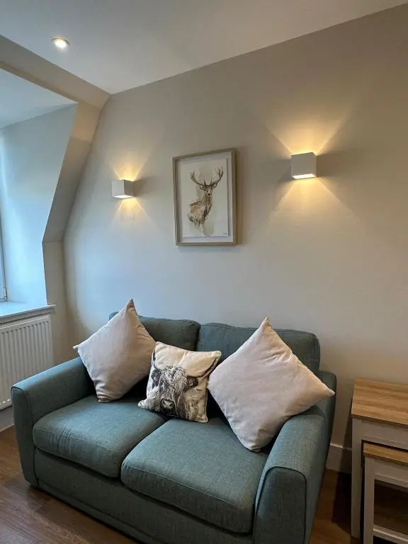 a living room with a blue couch with pillows at Highland Home on the Hill in Inverness
