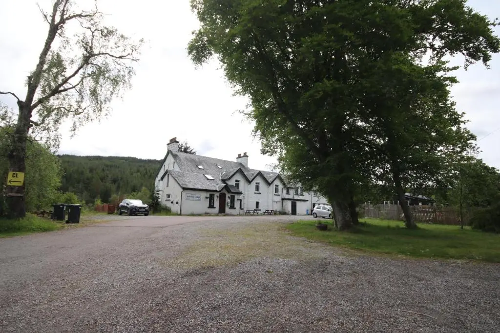 a white house with a tree in front of it at Tonita in Garve