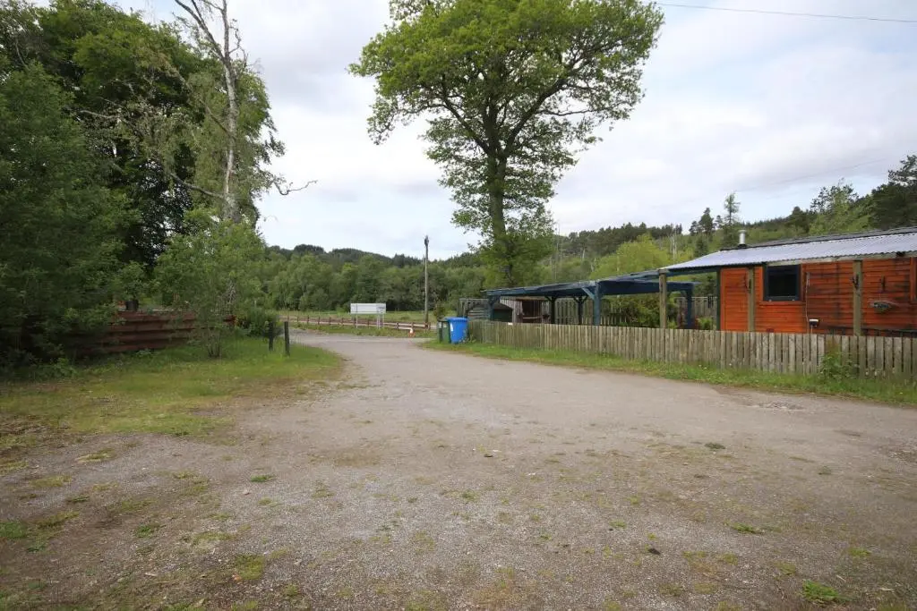 a train is parked next to a building at Woodlands Rest in Garve