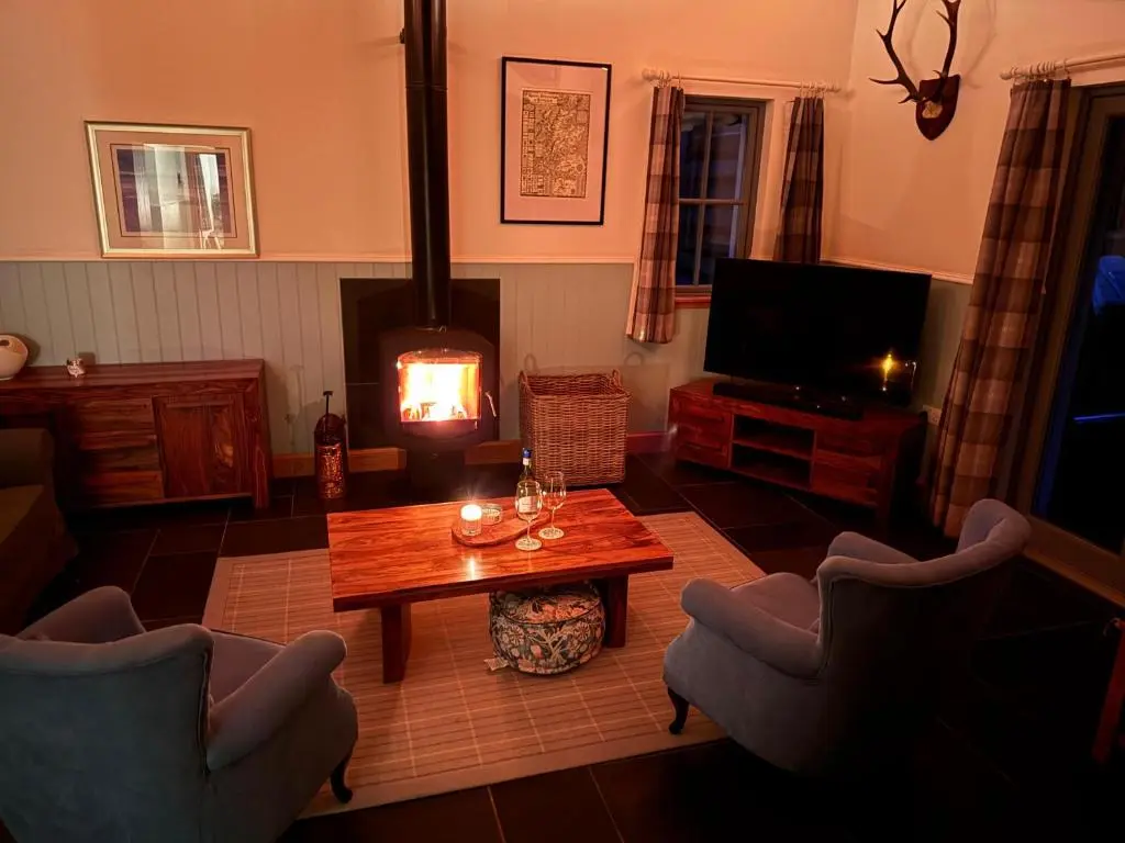 a living room with a coffee table and a television at Logies Croft in Kellas