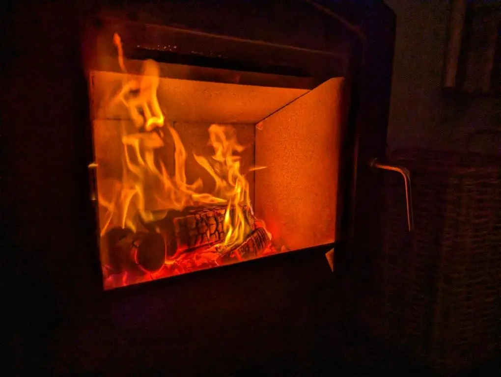 a fire in a fireplace with flames in it at Logies Croft in Kellas