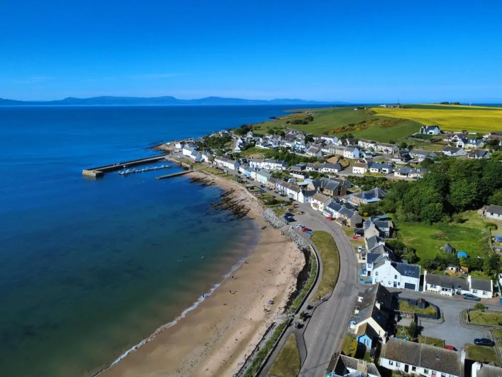 an aerial view of a beach with houses and the ocean at The Castle Hotel NR TAIN in Portmahomack