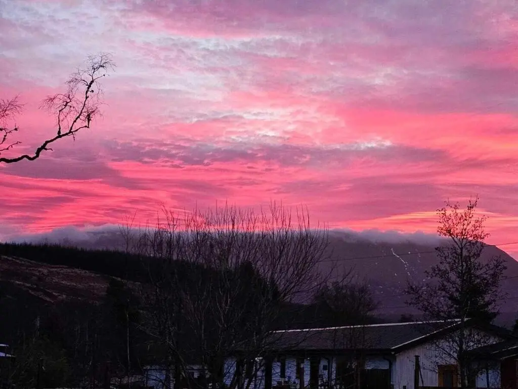 a sunset with a red sky with clouds at Owl View in Garve