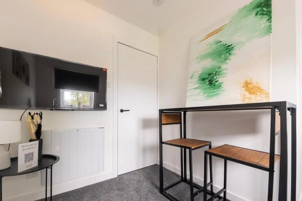 a room with two tables and a painting on the wall at 1 BDR Apartment At Caledonia Luxe Stays Short Lets & Serviced Accommodation Inverness in Inverness
