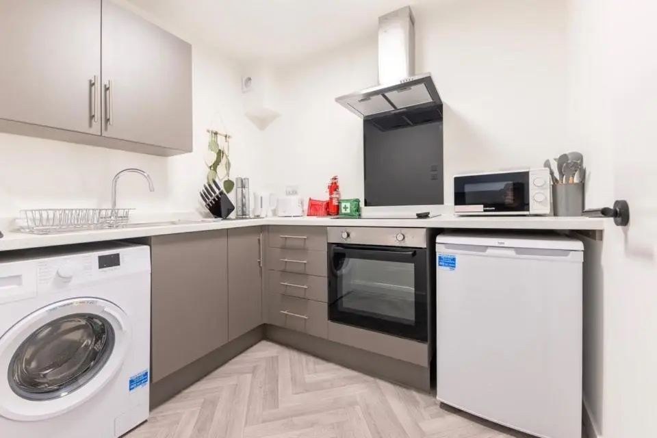 a kitchen with a washing machine and a washer at 1 BDR Apartment At Caledonia Luxe Stays Short Lets & Serviced Accommodation Inverness in Inverness