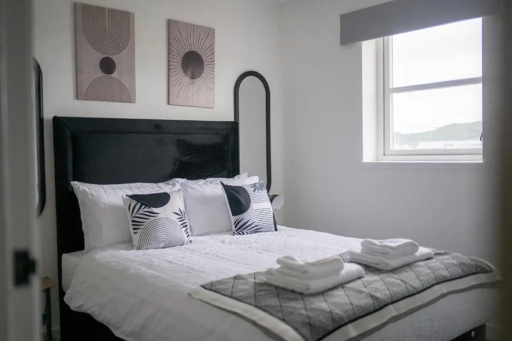 a bedroom with a bed with two towels on it at Dram Apartment in Inverness