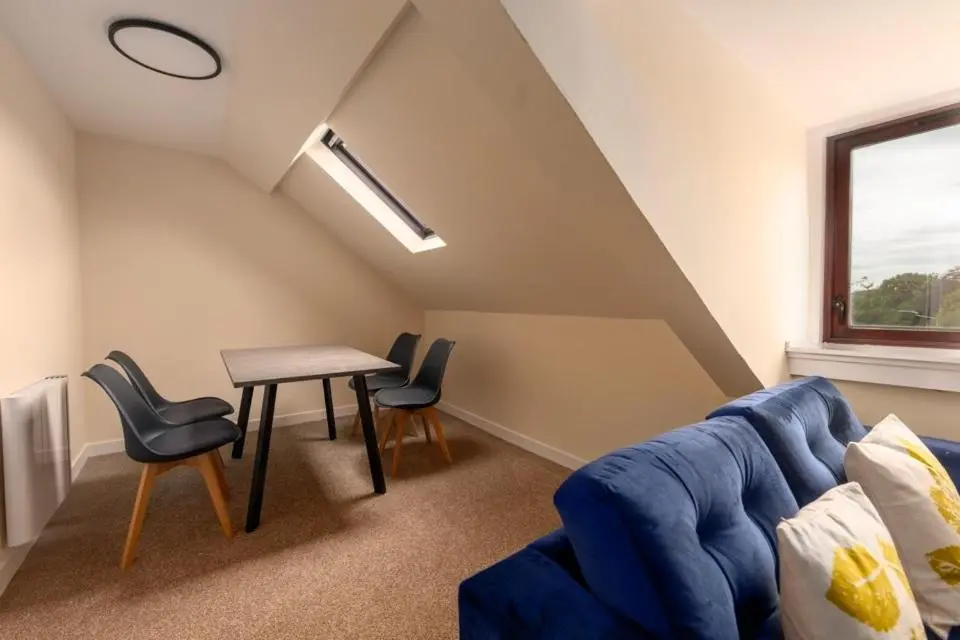 a living room with a blue couch and a table at 2 BDR Apt At Caledonia Luxe Stays Short Lets & Serviced Accommodation Inverness in Inverness