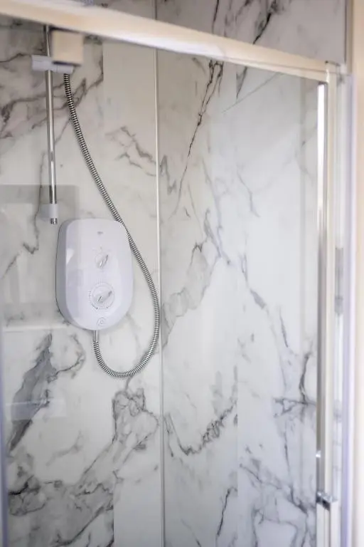 a shower in a bathroom with a white marble wall at 2 BDR Apt At Caledonia Luxe Stays Short Lets & Serviced Accommodation Inverness in Inverness