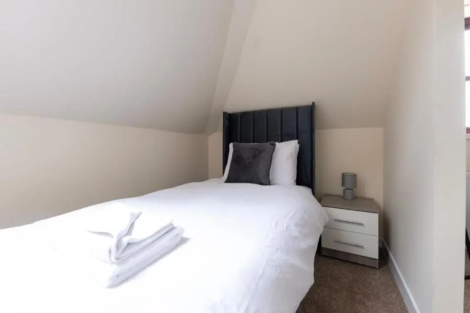 a bedroom with a white bed with a black headboard at 2 BDR Apt At Caledonia Luxe Stays Short Lets & Serviced Accommodation Inverness in Inverness
