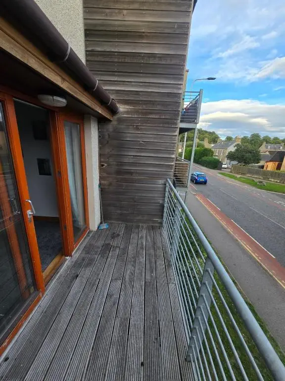 a wooden porch on a house with a street at Forres Nights in Forres