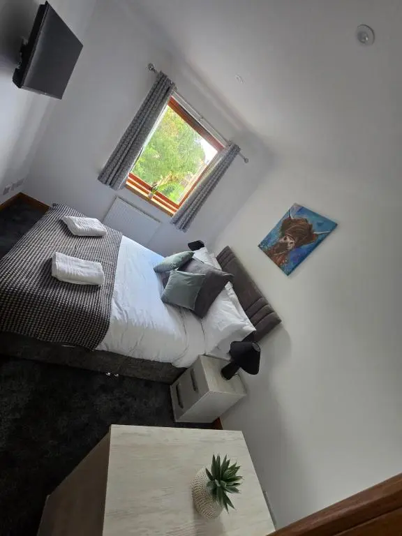 a small bedroom with a bed and a window at Forres Nights in Forres