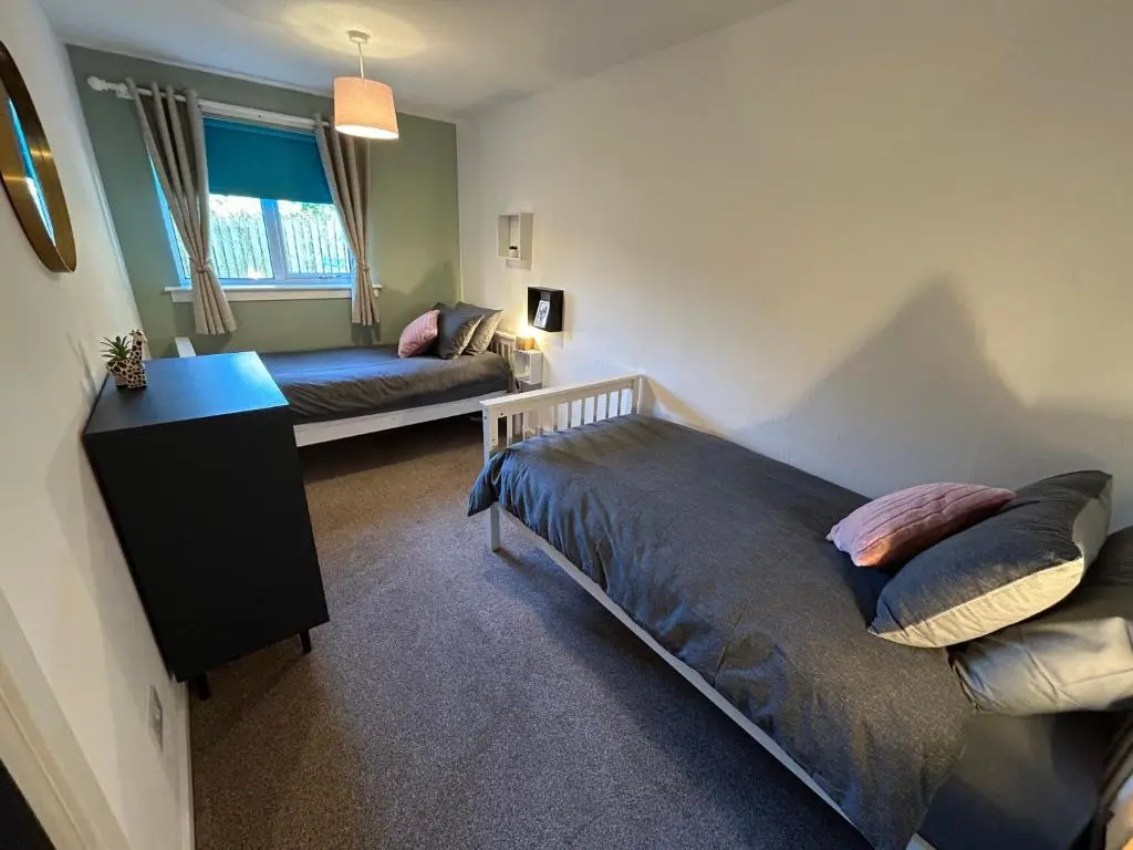 a bedroom with a bed and a couch in it at Cosy Flat Close to City Centre Ideal for Families in Dalneigh