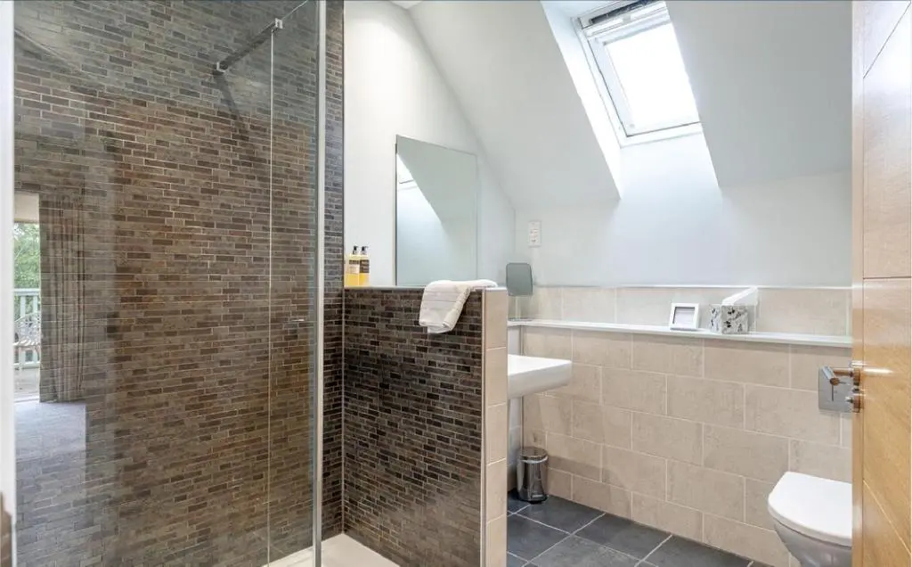 a bathroom with a glass shower and a sink at Sandown House in Nairn
