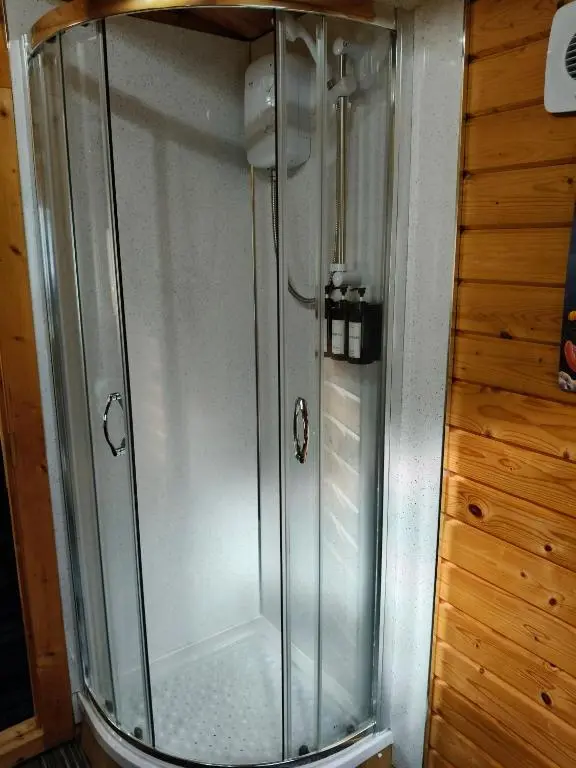 a shower with a glass door in a bathroom at Emili Fois in Tore