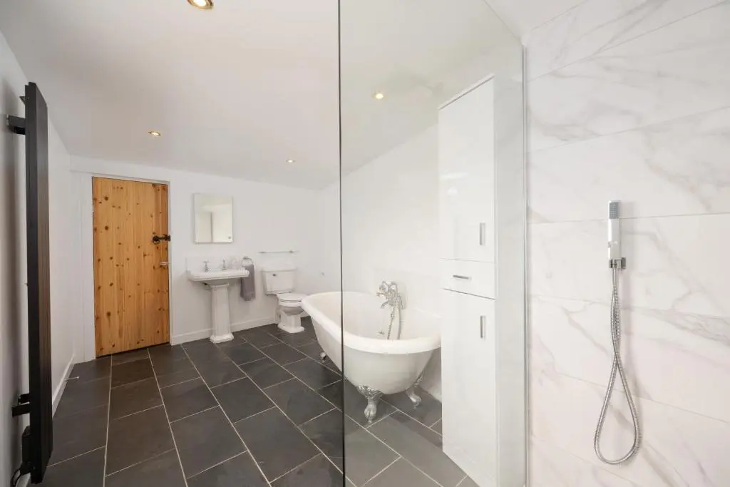 a bathroom with a tub and a toilet and a sink at Soundwaves, Seatown, Gardenstown in Gardenstown