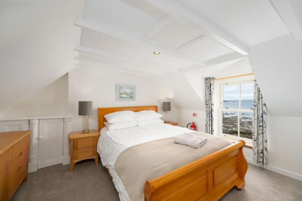 a bedroom with a large bed and a window at Soundwaves, Seatown, Gardenstown in Gardenstown