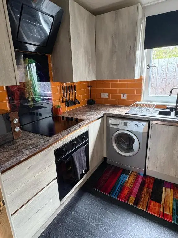 a kitchen with a washing machine on the floor at Cloverdale Aparthotel in Aberdeen