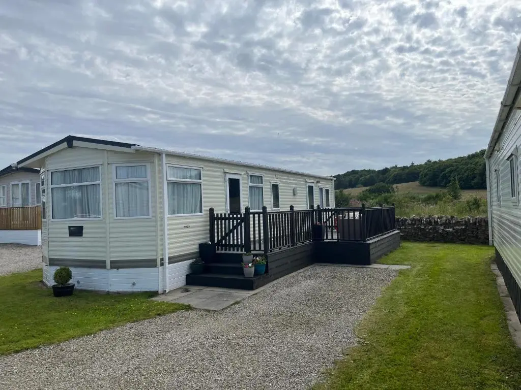 a mobile home parked next to a building at Number 28 Dornoch Firth Caravan Park in Dornoch