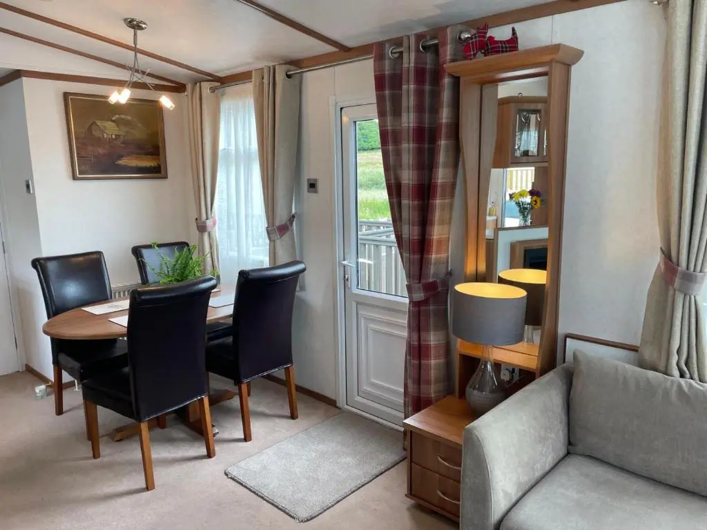 a living room with a table and chairs and a couch at Number 28 Dornoch Firth Caravan Park in Dornoch