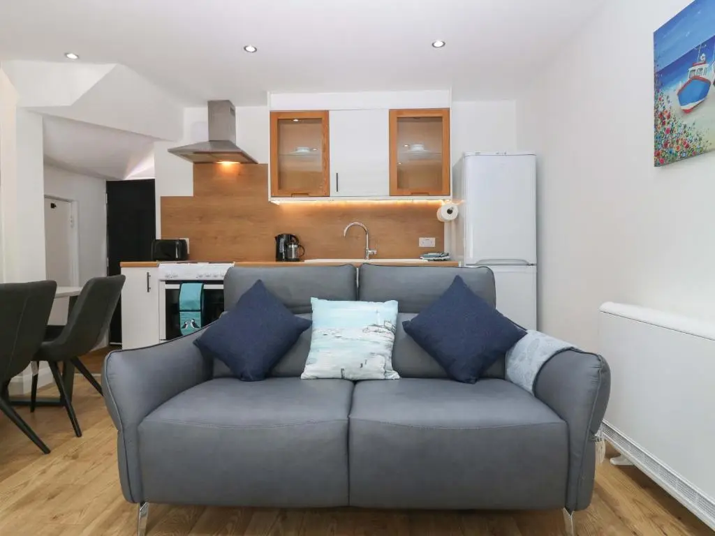 a living room with a couch and a kitchen at 3 Caroline Place in Fraserburgh
