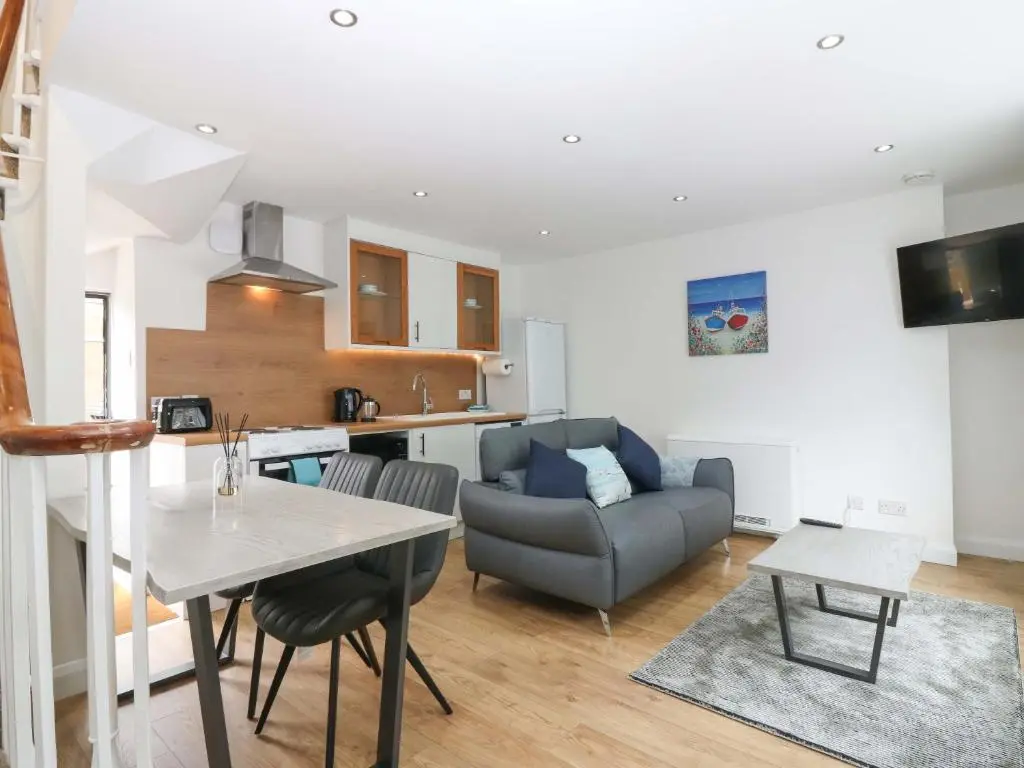 a kitchen and living room with a table and a couch at 3 Caroline Place in Fraserburgh
