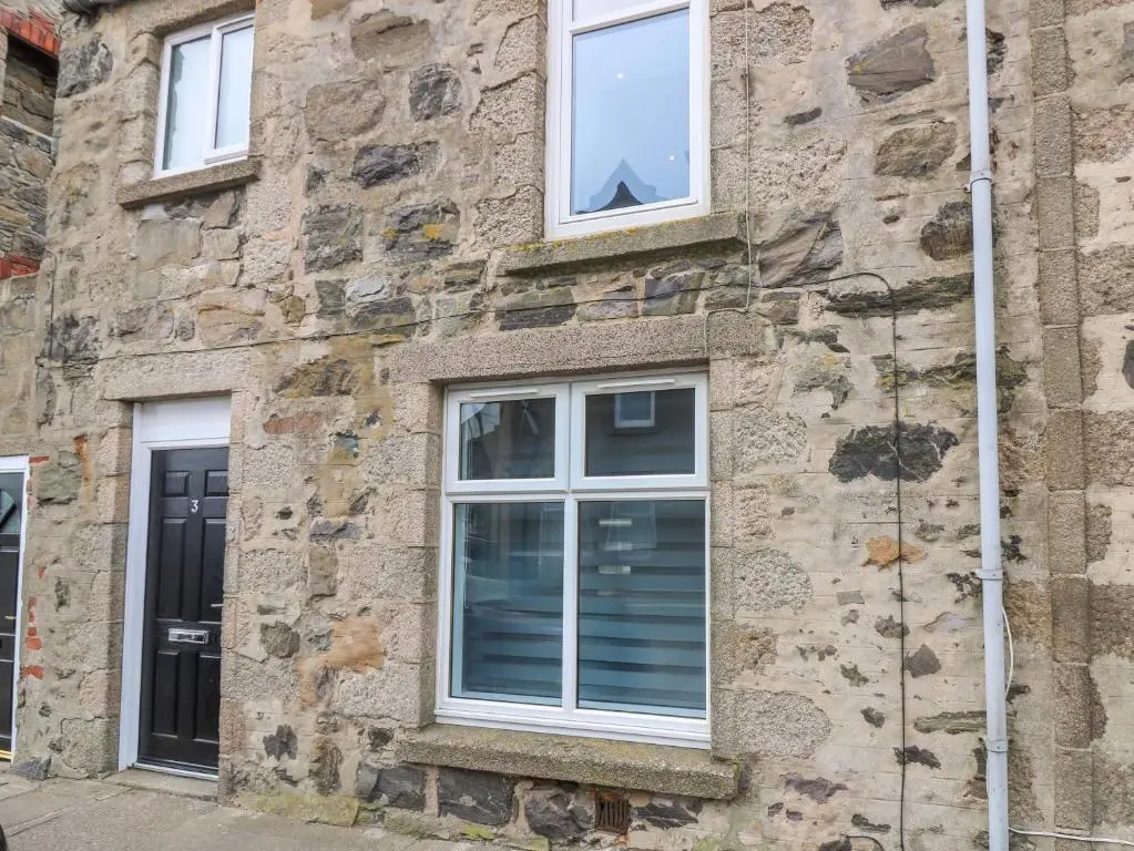 a stone building with two windows on it at 3 Caroline Place in Fraserburgh