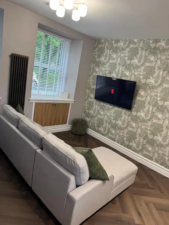 a living room with a couch and a flat screen tv at Luxury central townhouse in Wick