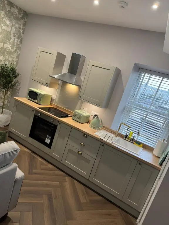 a kitchen with a sink and a stove top oven at Luxury central townhouse in Wick