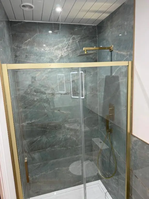 a shower with a glass door in a bathroom at Luxury central townhouse in Wick